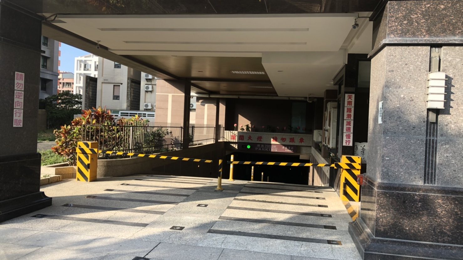 社區大樓車道入口，柵欄機與車牌辨識設備